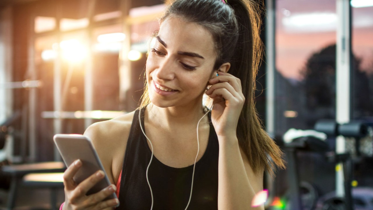 mulher na academia com o celular