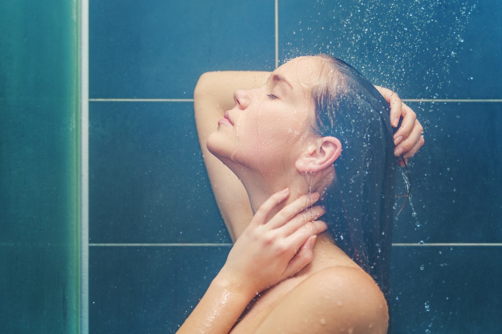 Mulher lavando o cabelo no chuveiro