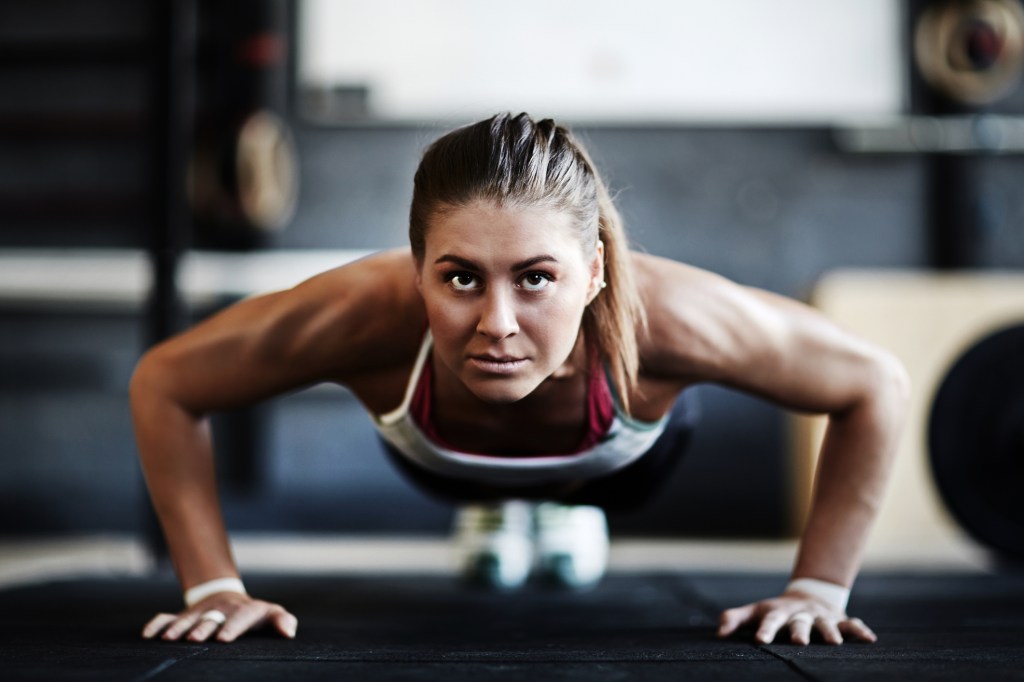 Mulher atlética na academia fazendo flexão de braço