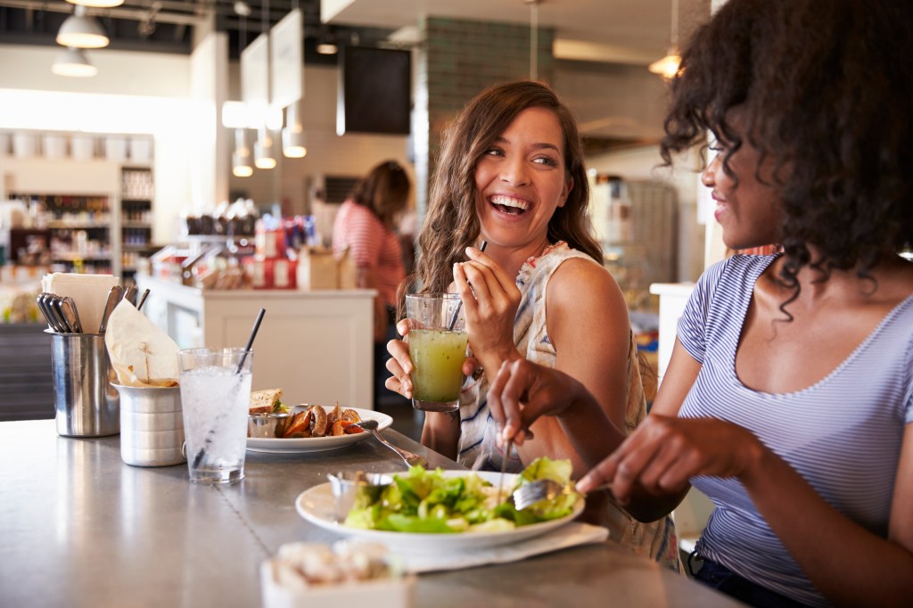 Duas amigas comendo no restaurante