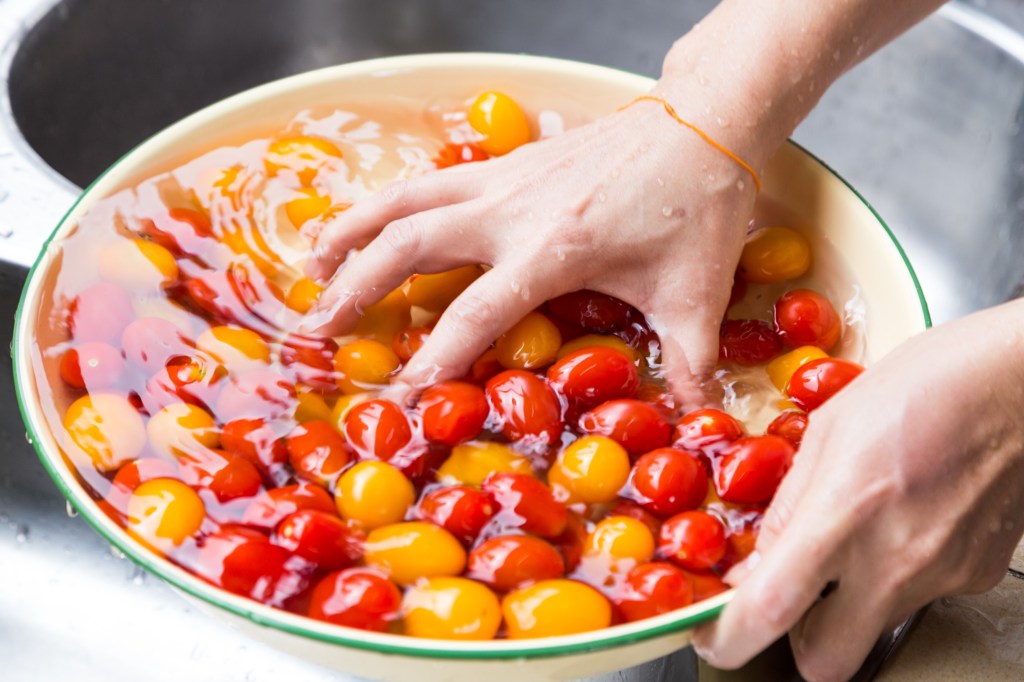 Pessoa lavando tomates