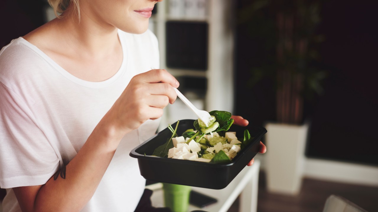 Mulher comendo salada