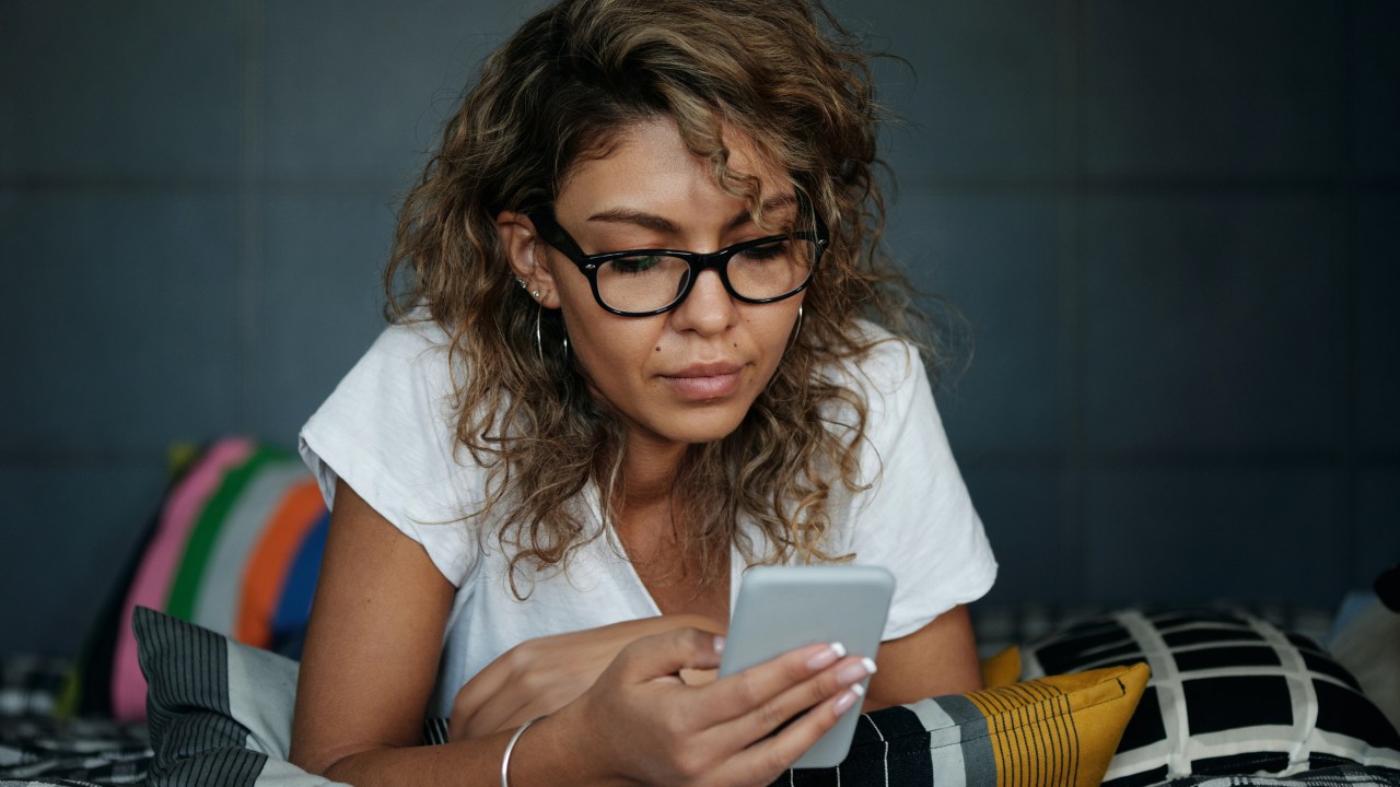 mulher deitada mexendo no celular