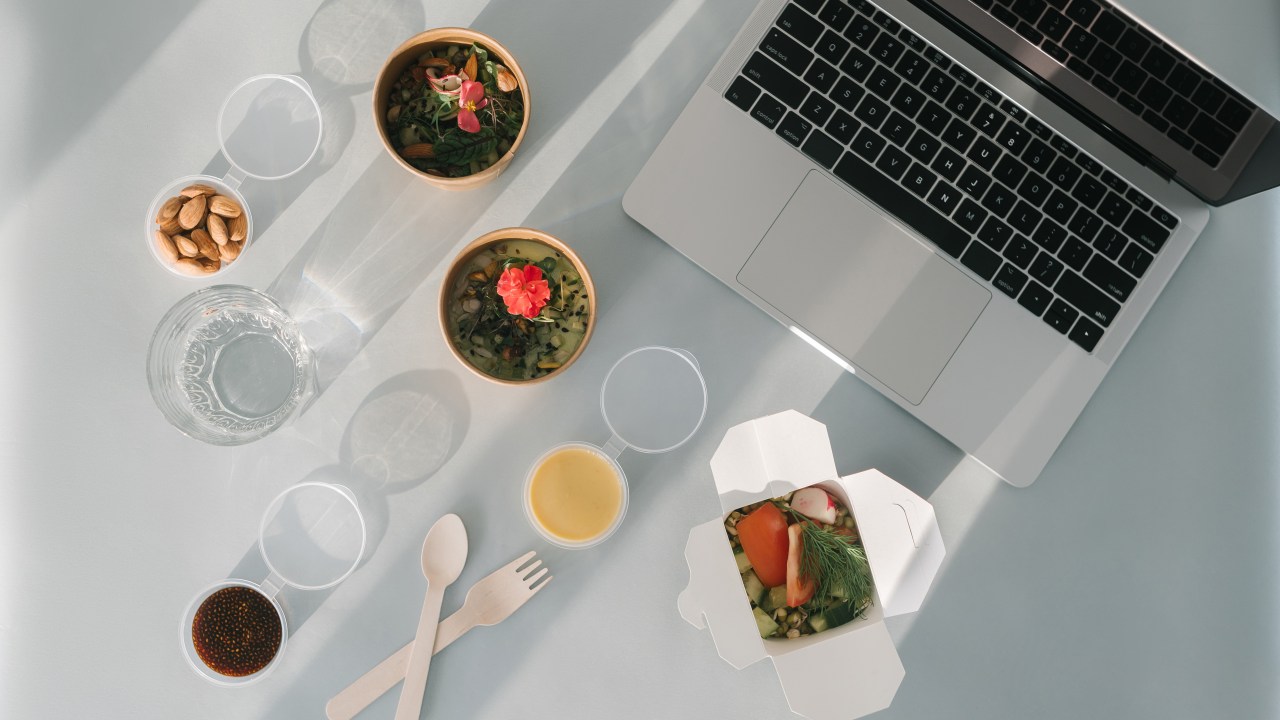 Várias embalagens com comida ao lado de um computador