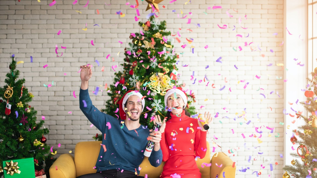 homem e mulher estourando confete no natal