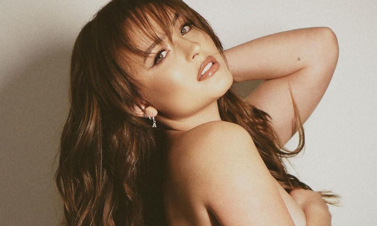 Larissa Manoela tampando os seios com o braço