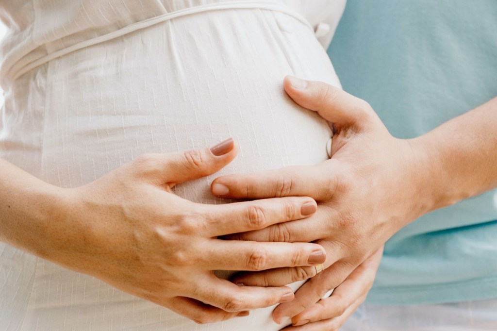 Foto De Mãos Tocando A Barriga de uma mulher grávida