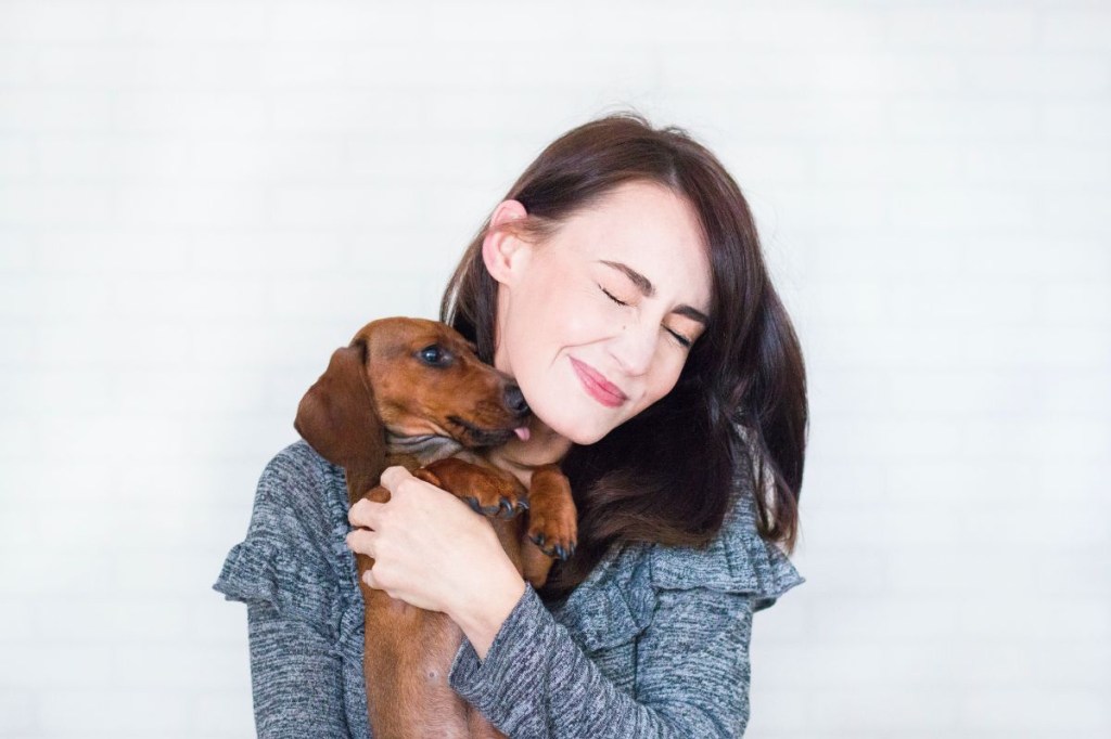 Mulher abraçando cachorro