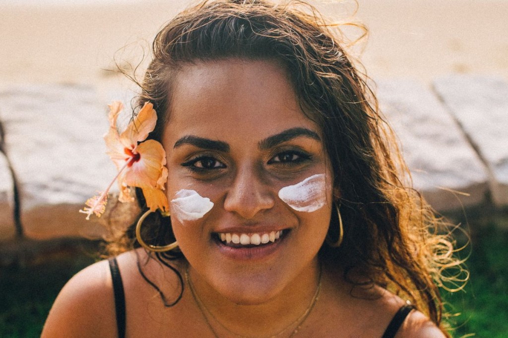 Mulher com protetor solar no rosto