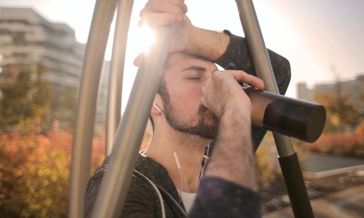 Esportista cansado bebendo água durante o treino