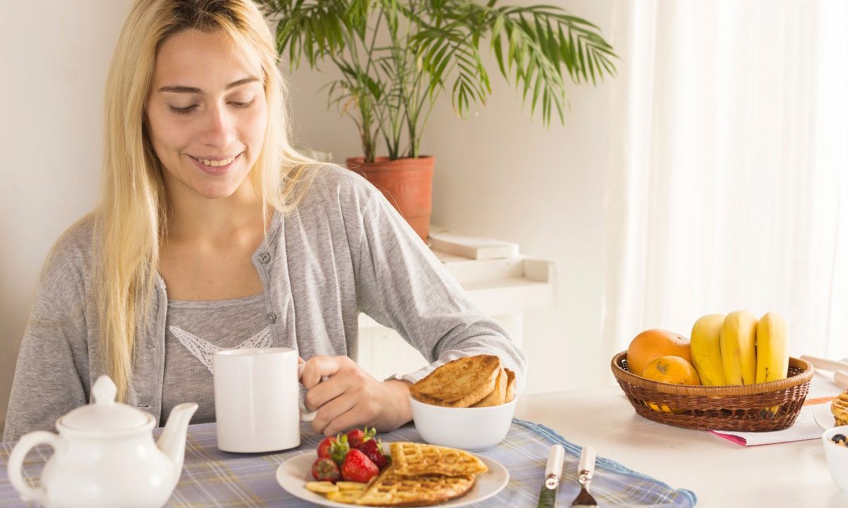 Mulher loira tomando café da manhã