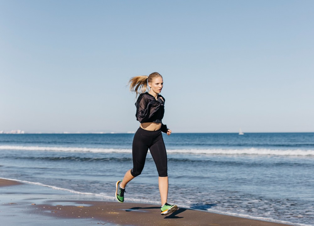 mulher fazendo corrida na areia