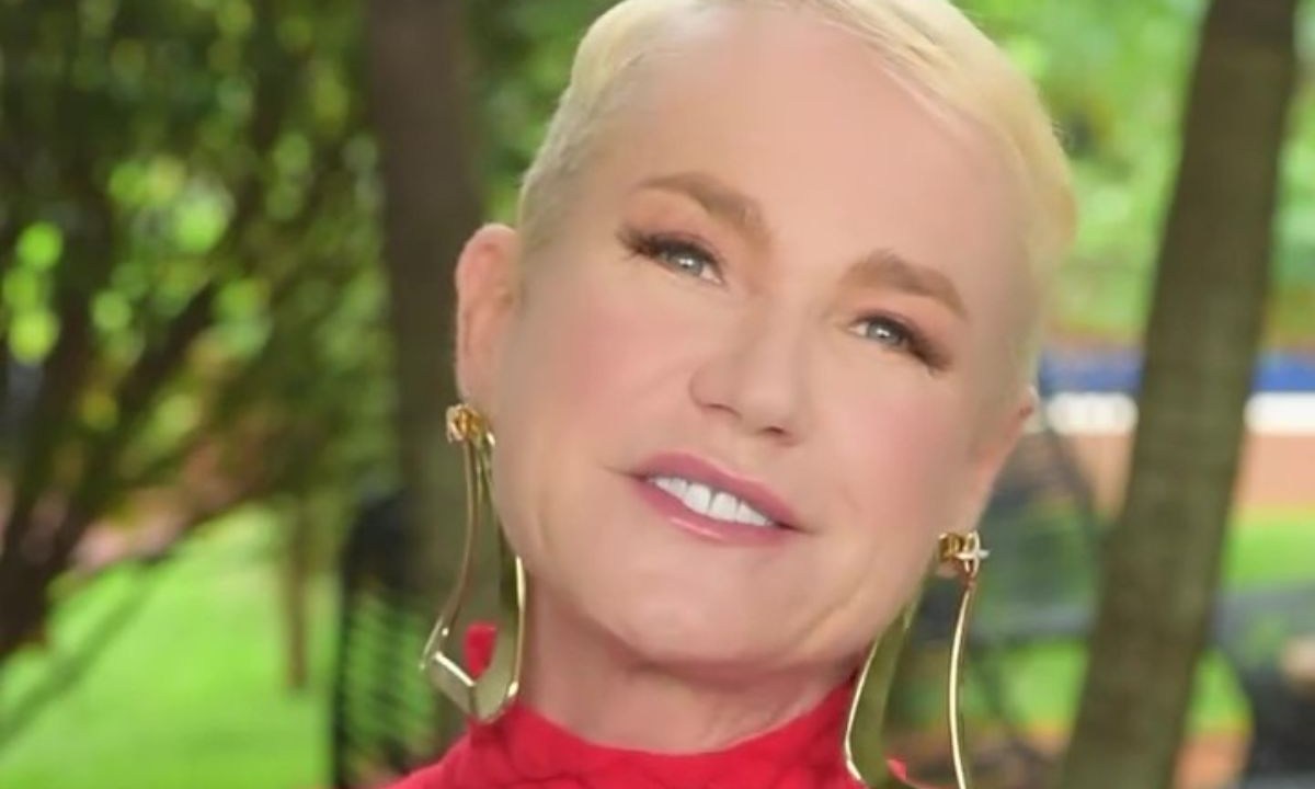 Xuxa sorrindo e utilizando brincos dourados longos